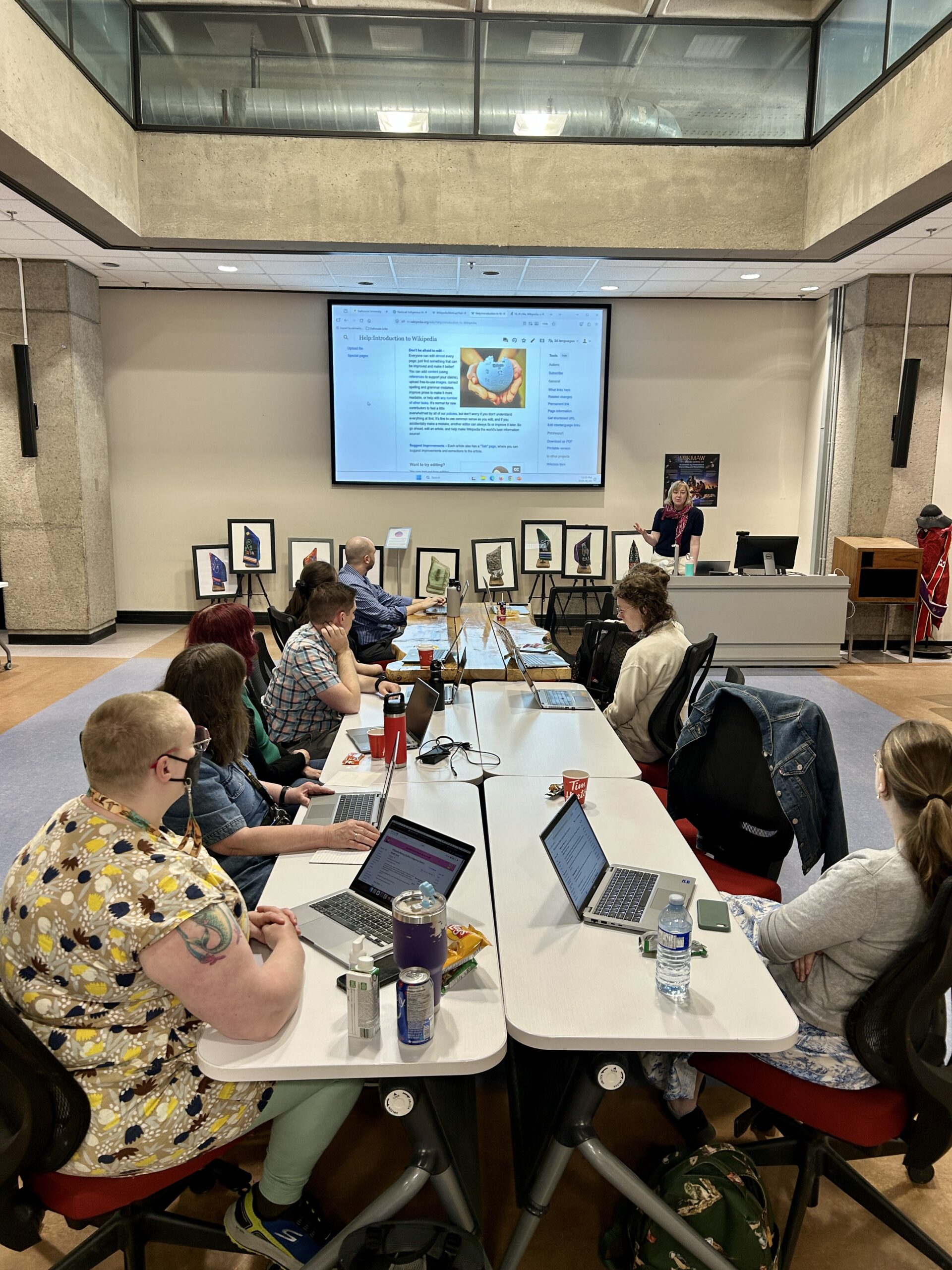 Editors sitting around a long table, facing a presentation at the front of the room
